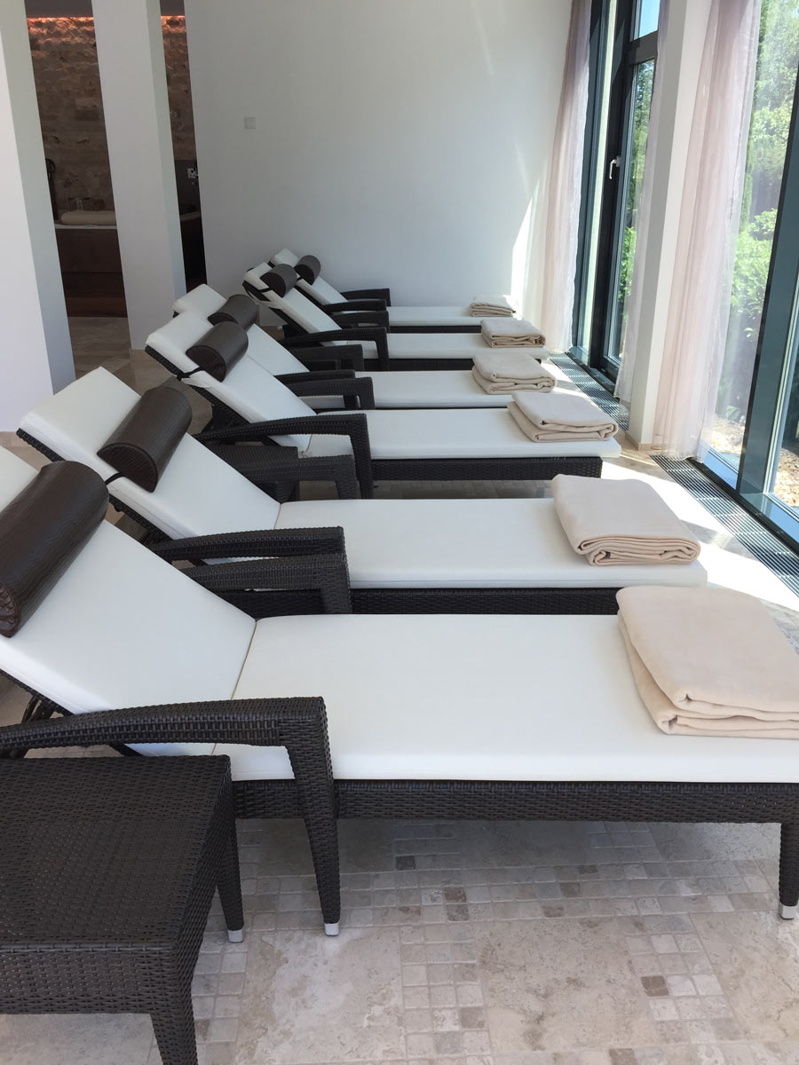 Relaxliegen im Innenbereich des Pools